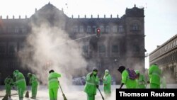 Un grupo de trabajadores desinfecta la plaza del Zócalo, en Ciudad de México, una de las ciudades más afectadas por la pandemia en la región.