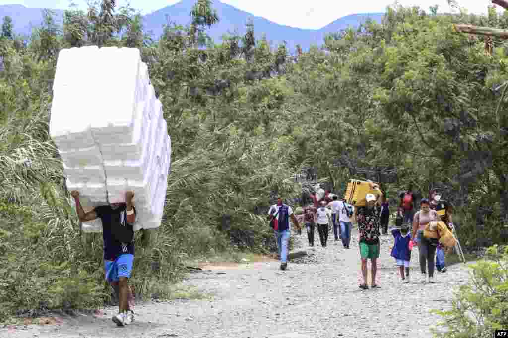 People cross from San Antonio del Tachira in Venezuela to Cucuta in Colombia through "trochas" -illegal trails- near the Simon Bolivar international bridge, Oct. 5, 2021.
