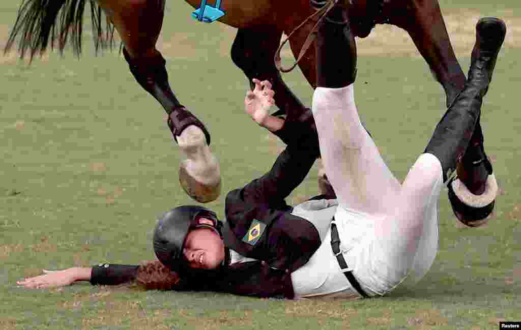 Ieda Guimaraes of Brazil falls from her horse during the equestrian portion of the women's modern pentathlon at the 2020 Summer Olympics, in Tokyo, Japan. 