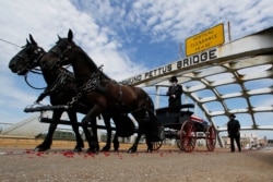 The casket with the body of John Lewis moves over the Edmund Pettus Bridge by horse-drawn carriage during a memorial service for Lewis, in Selma, Alabama, July 26, 2020.