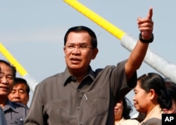 Cambodia's Prime Minister Hun Sen, center, gestures during a ceremony inaugurating the country's longest bridge in Neak Loeung, southeast of Phnom Penh, Cambodia, Wednesday, Jan. 14, 2015. Hun Sen, Cambodia's tough and wily prime minister, marks 30 years
