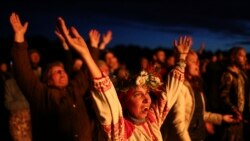 People wearing traditional Russian village-styled clothes, celebrate the summer solstice around a bonfire in Okunevo village, some 200 kilometers (124 miles) northeast from Siberian city of Omsk, Russia, Monday, June 21, 2021.