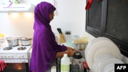 FILE - A refugee from Somalia, who had previously attempted to commit suicide, is seen doing kitchen chores at Camp Five on the Pacific island of Nauru, Sept. 2, 2018.