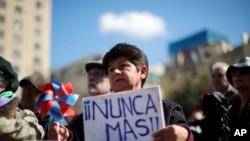 Una persona sostiene la frase "¡Nunca más!" en las afueras del palacio presidencial de La Moneda, durante una ceremonia que conmemora el 50 aniversario del golpe militar de 1973 que derrocó al presidente Salvador Allende, en Santiago, el 11 de septiembre de 2023.