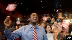 FILE - Jean Naason, 39, of Haiti, left, waves an American flag during a naturalization ceremony administered by the U.S. Citizenship and Immigration Services (USCIS) in Miami, June 5, 2014.