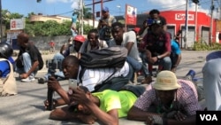 Haitian journalists lay on the street to avoid being shot during altercation between Haitian National Police and protesters, Oct. 31, 2019 in Port-au-Prince, Haiti. (Photo: Matiado Vilme)