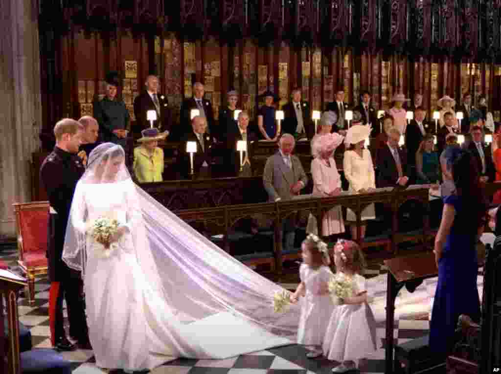 Vestido sencillo que sorprendió a medio mundo. Seda blanca con&nbsp;manga francesa, cola y&nbsp;escote barco,&nbsp;para no distraer la atención de la novia. Para algunos los "cortes simples y siluetas ajustadas" son habituales en el vestuario de Markle.