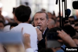 Turkish President Recep Tayyip Erdogan addresses the crowd following a funeral service for victims of the thwarted coup in Istanbul at Fatih Mosque in Istanbul, July 17, 2016.
