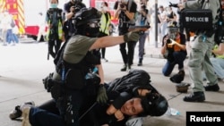 Policajci privode učesnika protesta protiv zakona o bezbednosti u Hong Kongu, 1. jul 2020.