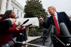 President Donald Trump takes a question as he speaks with reporters before departing for France, on the South Lawn of the White House, Nov. 9, 2018, in Washington.