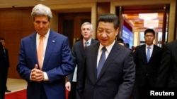 U.S. Secretary of State John Kerry (L) talks with China's President Xi Jinping at the U.S.-China Strategic and Economic Dialogue in Beijing, July 9, 2014.