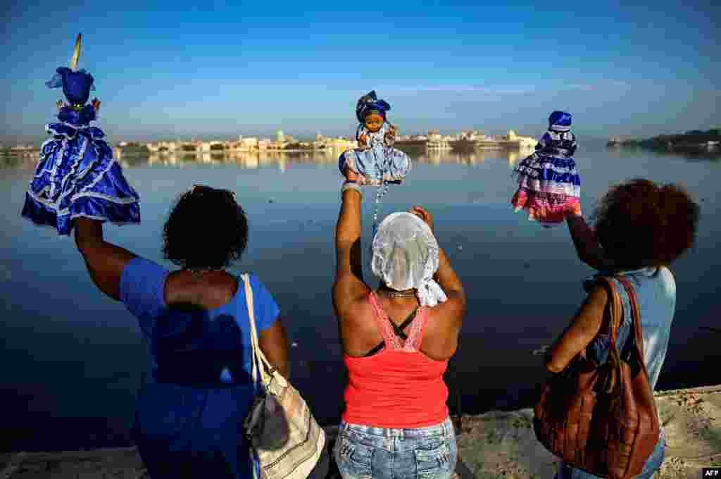 Followers of the Yoruba sea goddess Yemaya, give offering at the Havana harbor during Yemaya Day celebrations in Havana, Cuba.