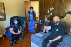 John McFarland (70), menunjukkan kartu vaksinasi setelah menerima vaksinasi COVID-19 di dalam kamar tidurnya di Hayward, California, 6 Mei 2021.