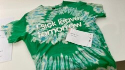 香港市民Phoenix 在反送中運動兩周年義賣活動，以物易物方式帶走一件喻意飲水思源的T恤。(美國之音 湯惠芸拍攝)