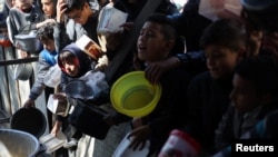 ჰუმანიტარული დახმარების რიგში, პალესტინელები საკვების მისაღებად დგანან. რაფა, ღაზის სექტორი. 5 თებერვალი, 2024 წ.