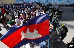 រូបឯកសារ៖ បាតុករ​ប្រមូល​ផ្តុំ​គ្នា​នៅ​មុខ​កង​កម្លាំង​ប៉ូលិស​បាំង​ដោយ​រនាំង​ដែក​នៅ​កណ្តាល​ផ្លូវ​ក្បែរ​តុលាការ​ក្រុង​ភ្នំពេញ​ នៅ​រាជធានី​ភ្នំពេញ កាល​ពី​ថ្ងៃ​ពុធ ទី១៦ ខែ​កក្កដា ឆ្នាំ២០១៤។ (រូបថត៖ AP/ហេង ស៊ីនិត)