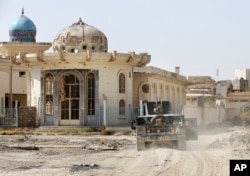 FILE - Iraqi counter-terrorism forces advance their positions in Fallujah, June 22, 2016. Pockets of Islamic State fighters continue to hold neighborhoods along the north and west of the city.