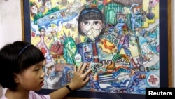 Nguyen Doi Chung Anh, 10, a Vietnamese school girl stands next to her painting about the coronavirus disease (COVID-19) at home in Hanoi, Vietnam June 10, 2020. (REUTERS/Kham)
