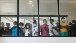 FILE — In this Feb, 17 2021 file photo, health care workers look through a window at a hospital in Khayelitsha, Cape Town, South Africa during the rollout of the first batch of Johnson and Johnson vaccines in the country.