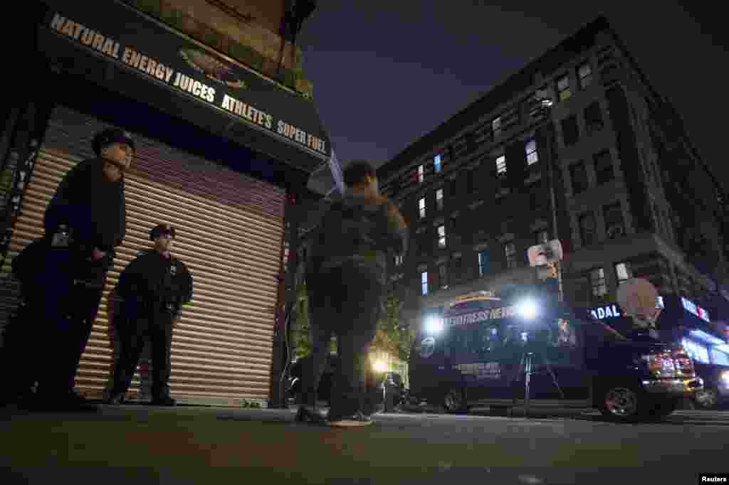 Police stand guard across the street from Dr. Craig Spencer's apartment, after it was confirmed that he tested positive for Ebola, New York City, Oct. 23, 2014. 