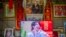 FILE - A television shows a broadcast of a Chinese talk show program as it sits beneath a photo of Chinese President Xi Jinping in a home converted into a tourist homestay in Zhaxigang village in western China's Tibet Autonomous Region, June 4, 2021.