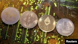 FILE - Representations of the Ripple, Bitcoin, Etherum and Litecoin virtual currencies, Feb. 13, 2018. Switzerland's government wants to look into the feasibility of launching its own state-backed cryptocurrency.