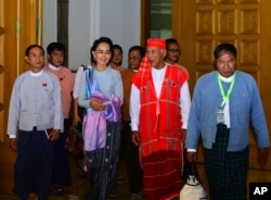 FILE - Myanmar opposition leader Aung San Suu Kyi, second from left, walks with members of her National League for Democracy party upon their arrival to attend regular session of the parliament's Lower House in Naypyitaw, Myanmar, Dec 1, 2015.