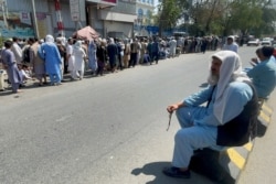 Afghans line up outside a bank to take out their money after Taliban takeover in Kabul, Sept. 1, 2021.