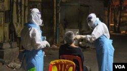 រូប​ឯកសារ៖ បុគ្គលិកសុខាភិបាលកំពុងយកសំណាកពីប្រជាពលរដ្ឋនៅក្នុងរាជធានីភ្នំពេញ ដើម្បីធ្វើតេស្តរកជំងឺកូវីដ១៩ កាលពីថ្ងៃទី ០៨ ខែមេសា ឆ្នាំ ២០២១។ (ទុំ ម្លិះ/វីអូអេ)