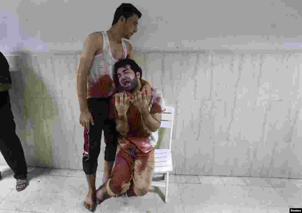 Falastinlik o'g'il Isroil havo hujumida o'lgan otasiga motam tutayapti. 23-iyul, 2014-yil.