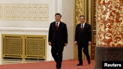 2022年10月23日在北京人大会堂，李强跟在中国领导人习近平后面与媒体会面。