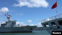 FILE - A Chinese People's Liberation Army replenishment ship, left, sails past a PLA navy hospital ship as it docks at the Joint Base Pearl Harbor Hickam to participate in the multinational military exercise RIMPAC 2014, in Honolulu, Hawaii, June 24, 2014.