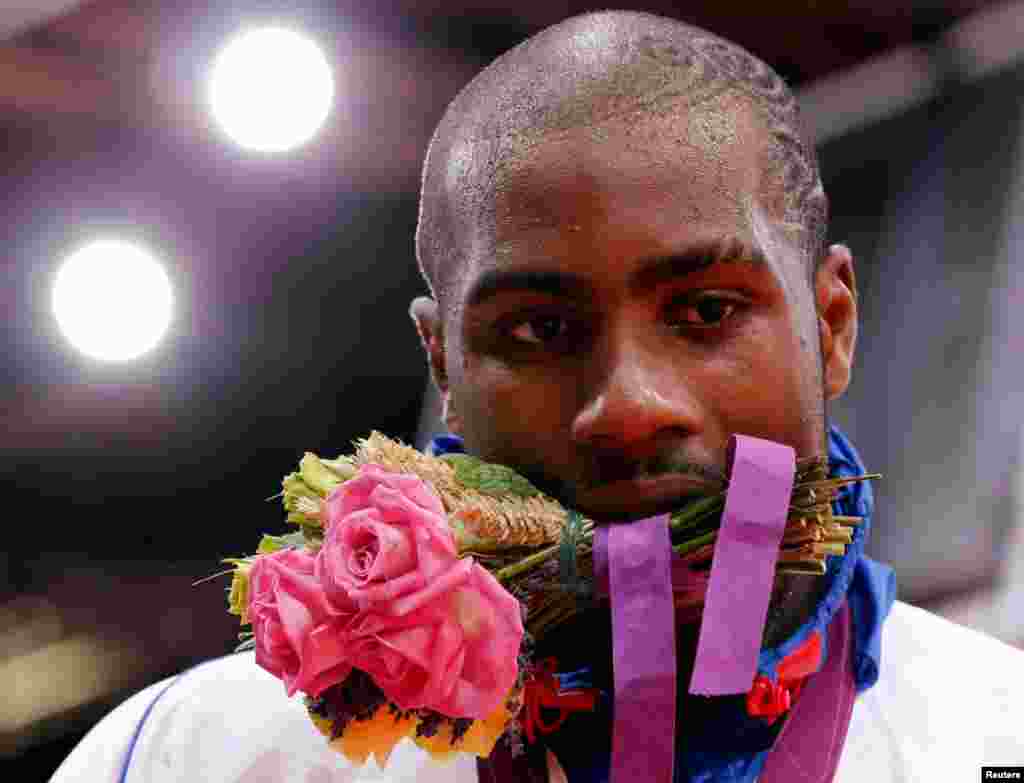 Gold medalist Teddy Riner, of France, holds his bouquet at the victory ceremony for the men's +100kg judo event.