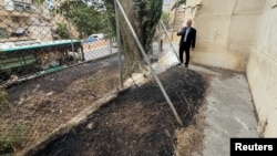 联合国近东救济工程处约旦河西岸事务主任亚当·布鲁克斯（Adam Bouloukos）向人们展示该机构总部旁被当地以色列居民纵火焚烧后的情景。（2024年5月10日）