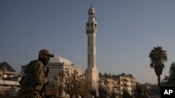 A member of the security forces of the newly formed Syrian government patrols an area near to a security checkpoint in Homs, Syria, Dec. 26, 2024.
