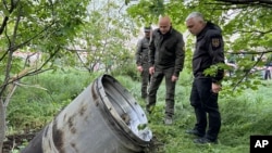 مقامات بندر اودسا در حال بررسی قطعه‌ای از موشکی هستند که انفجار آن، چند کشته و زخمی برجا گذاشت.