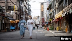 FILE - Women wear kimonos in the street at the Senso-ji temple area in Tokyo, Japan, August 18, 2021. (REUTERS/Molly Darlington)