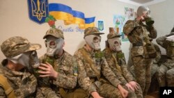 Курсанти тренуються користуватися протигазами у бомбосховищі в Києві. AP Photo/Efrem Lukatsky