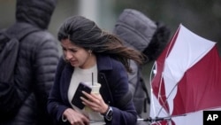 Una transeúnte lucha con los fuertes vientos, el jueves 4 de abril de 2024, en Boston. 