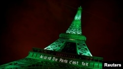 FILE - The Eiffel Tower is illuminated in green with the words "Paris Agreement is Done," to celebrate the day on which the Paris Agreement to fight climate change entered into force, Nov. 4, 2016.