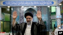 Ebrahim Raisi, mmoja wa wagombea urais akinyanyua mikono yake wakati alipomaliza kupiga kura huko Tehran, Iran, Ijumaa, Juni 18, 2021. 