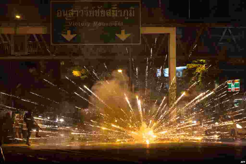 Fireworks, thrown by protesters, explode in front of a line of police during a demonstration against Thai Prime Minister Prayut Chan-O-Cha and his government's handling of the Covid-19 crisis in Bangkok.