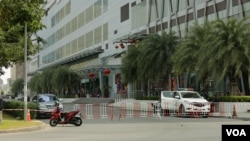 អគារ The Bridge ត្រូវបានបិទនិងពង្រឹងសន្តិសុខពេលចេញចូល បន្ទាប់ពីមនុស្សក្នុងអគារនោះបានធ្វើតេស្តវិជ្ជមានថា មានជំងឺកូវីដ១៩ ក្នុងអំឡុងពេលមានការឆ្លងក្នុងសហគមន៍លើកទីបី នៅរាជធានីភ្នំពេញ ប្រទេសកម្ពុជា កាលពីថ្ងៃទី២៤ ខែកុម្ភៈ ឆ្នាំ២០២១។ (ទុំ ម្លិះ/វីអូអេ)