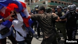 FILE: Protesters clash with police as they attempt to go toward the Phnom Penh Municipal Court, in central Phnom Penh April 25, 2014. 