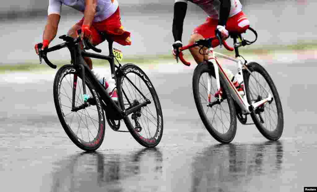 Guihua Liang of China and Shota Kawamoto of Japan compete in the men's cycling road C1-3 at the Fuji International Speedway during the&nbsp;Tokyo 2020 Paralympic Games in Oyama, Japan.