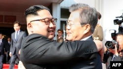 This picture taken on May 26, 2018 and released by the Blue House via Dong-A Ilbo shows South Korea's President Moon Jae-in (R) hugging North Korea's leader Kim Jong Un after their second summit at the north side of the truce village of Panmunjom.
