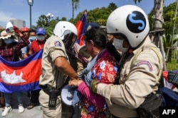 រូប​ឯកសារ៖ សន្ដិសុខ​រឹបអូស​ឧបករណ៍​បំពង​សំឡេង​ពី​បាតុករ​ម្នាក់ ក្នុង​អំឡុងពេល​នៃ​ការ​ធ្វើ​បាតុកម្ម​មួយ​ដើម្បី​ប្រារព្ធ​ខួប​ទី​២៩ នៃ​កិច្ចព្រមព្រៀង​សន្ដិភាព​ទីក្រុង​ប៉ារីស​នៅ​មុខ​ស្ថានទូត​សហរដ្ឋអាមេរិក រាជធានី​ភ្នំពេញ ​ថ្ងៃទី២៣ ខែតុលា ឆ្នាំ២០២០។