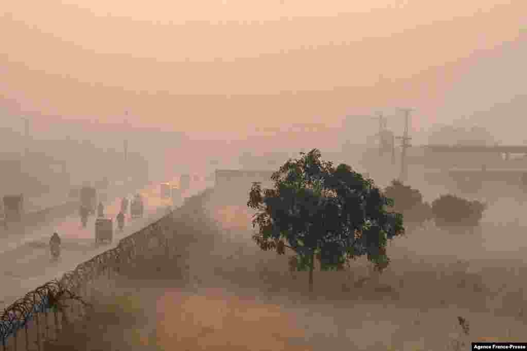People commute along a street amid heavy smoggy conditions in Lahore, Pakistan.