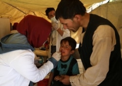 FILE - An internally displaced child from northern provinces receives medical treatment in a public park used as a shelter in Kabul, Afghanistan, Aug. 10, 2021.
