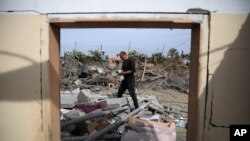 Palestinians inspect the ruins of a residential building for the Abu Muammar family after an Israeli airstrike in Rafah, Gaza Strip, on March 29, 2024.